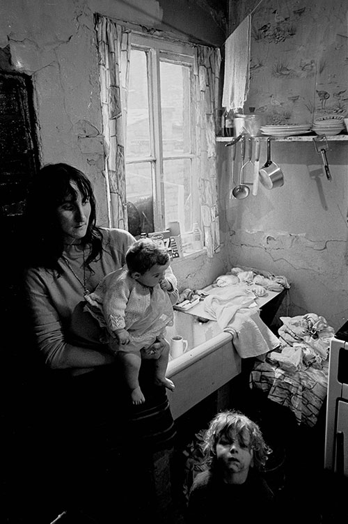 Mother and her children at the sink in their Salford condemned property,  (1971)