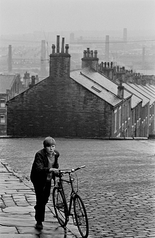 Boy wheeling his bicycle up a cobbled street, Bradford  (1969)