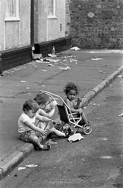 Children playing in the gutter of a street in Winson Green, Birmingham  (1971)