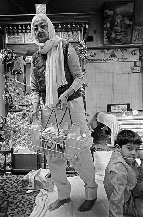 Removing gifts from the shrine to use in communal kitchen, Sikh temple, Wolverhampton  (1976)