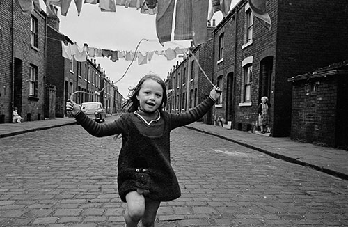 Child skipping in a street of back to back houses, Leeds  (1970)