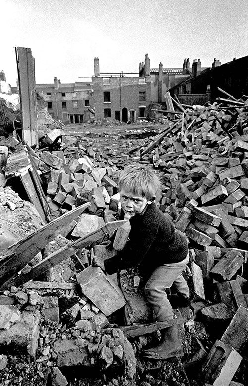 A toddler clambering over a demolished house, Ladywood, Birmingham  (1968)