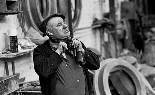 Foundryman tying his muffler at the end of the shift, Lee Howl pump factory Tipton  (1978)