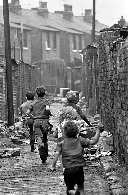 Gang of boys chase down a Manchester alleyway,  (1971)